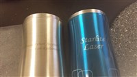 Stainless Steel travel mugs. The uncoated one is more expensive to engrave than the coated one because it takes longer to mark the steel than to burn off the paint.